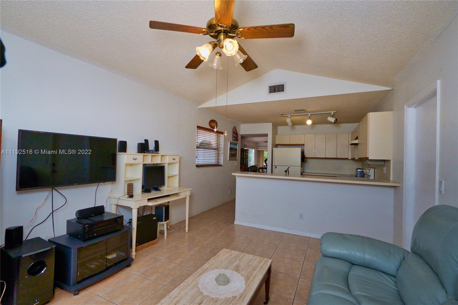 21291 Sawmill Court Boca Raton, FL 33498 - Photo 7 of 32 a living room with furniture and a flat screen tv