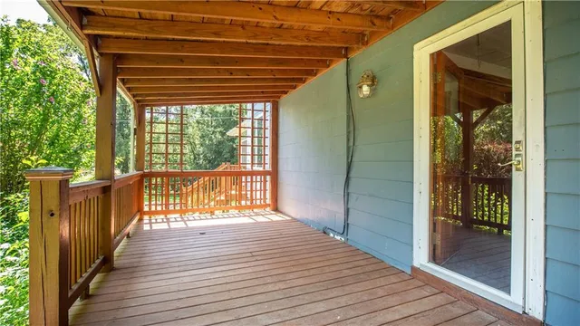 a view of a porch with wooden floor and floor to ceiling window