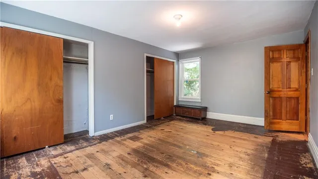 an empty room with closet and windows