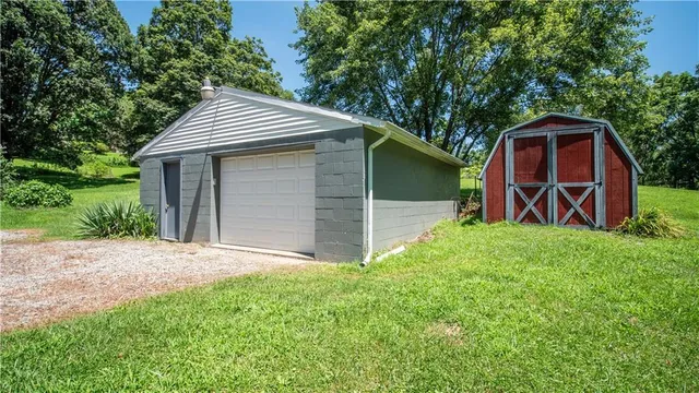 a view of a backyard with barn and wooden fence