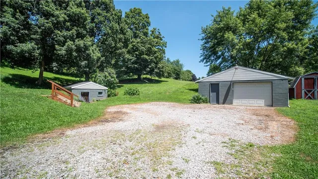 a front view of a house with a garden and trees