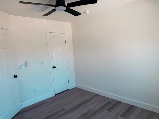 a view of room with hardwood floor and white walls