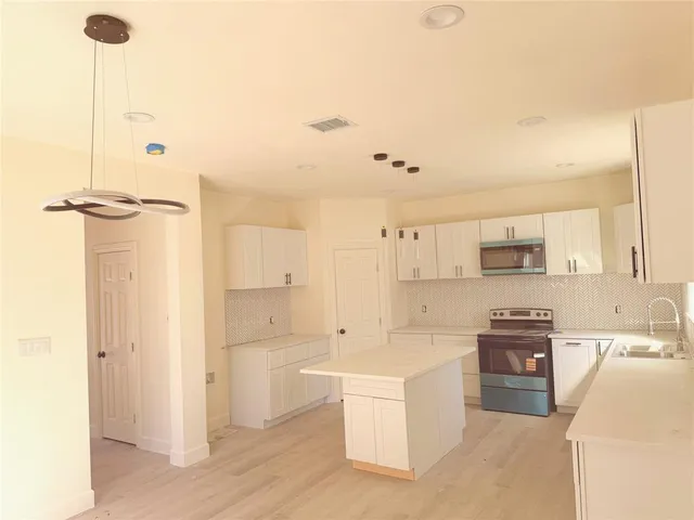 a view of a kitchen with electric appliances