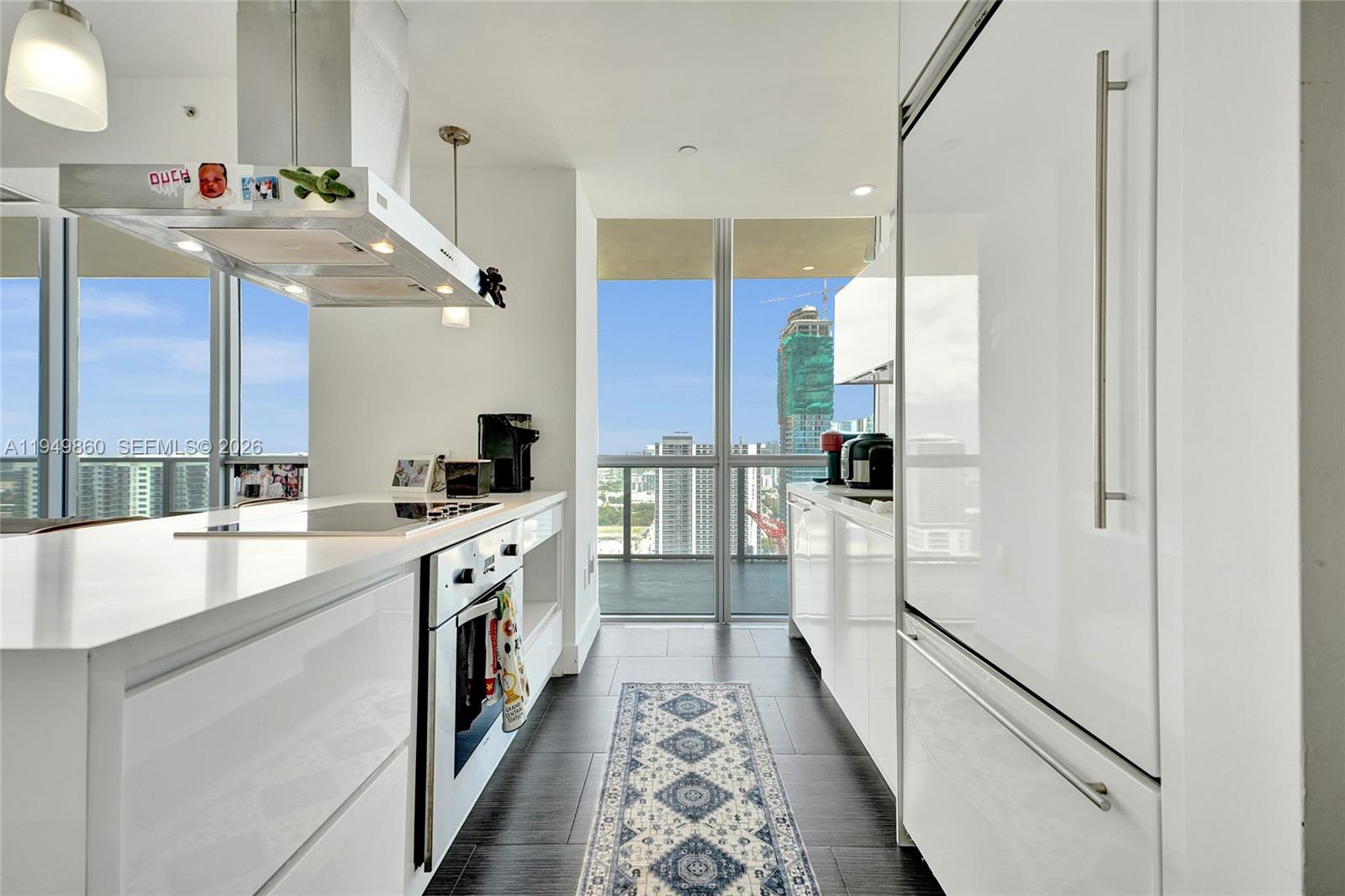 a kitchen with stainless steel appliances granite countertop a sink and a refrigerator