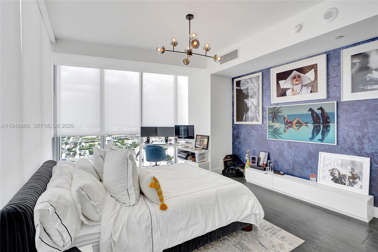 1100 Biscayne Boulevard, Unit 3708 Miami, FL 33132 - Photo 16 of 43 a bedroom with a large bed and a chandelier