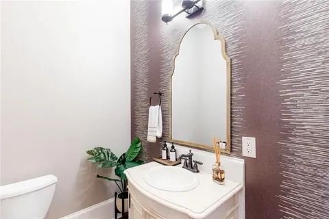 a kitchen with stainless steel appliances granite countertop a refrigerator a stove a sink a dining table and chairs with wooden floor