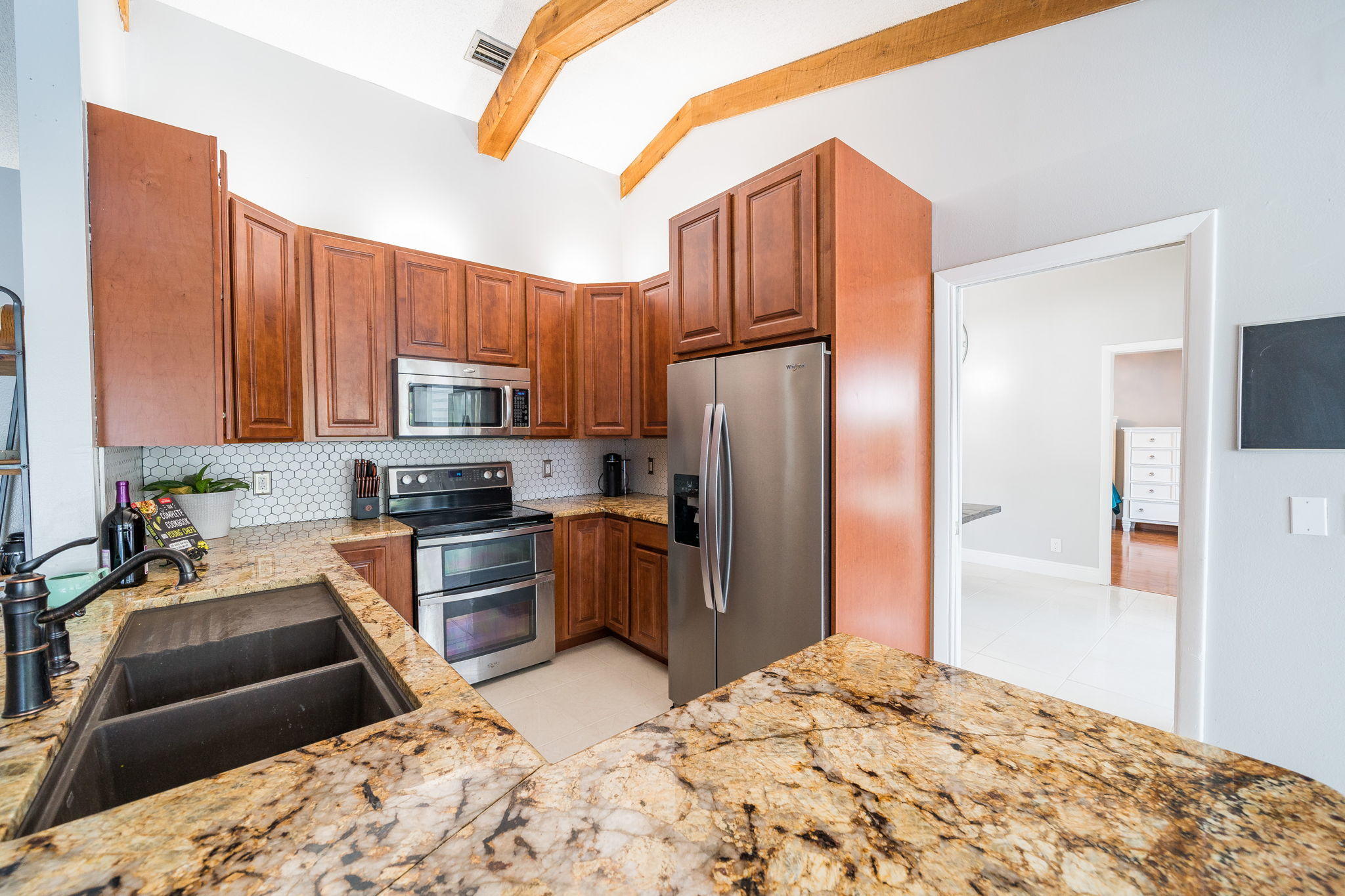 1877 Shower Tree Way Wellington, FL 33414 - Photo 17 of 47 a kitchen with stainless steel appliances kitchen island granite countertop a refrigerator stove top oven and sink