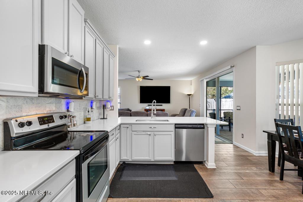 13694 Fish Eagle Drive West Jacksonville, FL 32226 - Photo 11 of 62 a kitchen with a sink stove and microwave