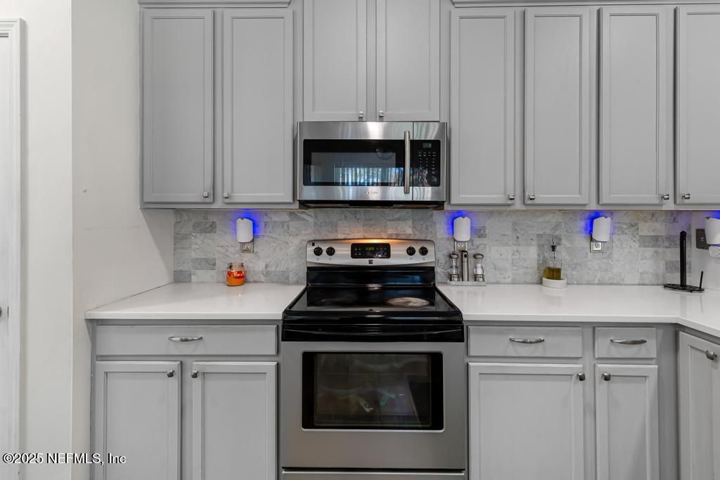 13694 Fish Eagle Drive West Jacksonville, FL 32226 - Photo 12 of 62 a kitchen with granite countertop white cabinets and a stove top oven