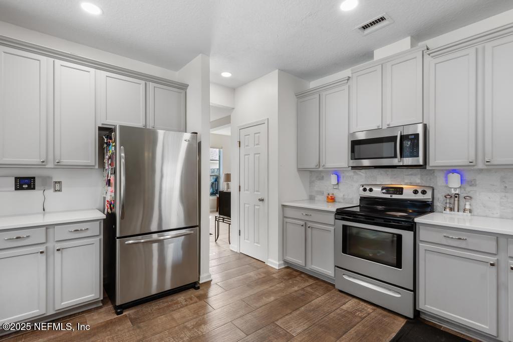13694 Fish Eagle Drive West Jacksonville, FL 32226 - Photo 15 of 62 a kitchen with stainless steel appliances white cabinets white and a refrigerator