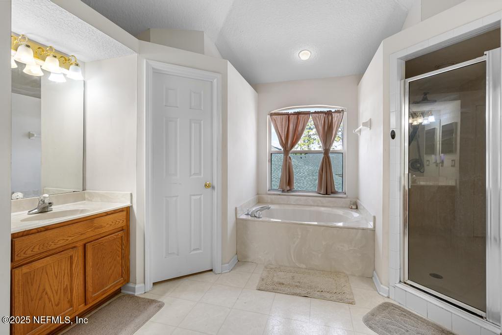 13694 Fish Eagle Drive West Jacksonville, FL 32226 - Photo 38 of 62 a bathroom with a granite countertop sink a mirror and a bathtub