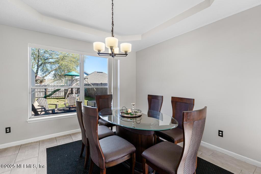 13694 Fish Eagle Drive West Jacksonville, FL 32226 - Photo 9 of 62 a dining room with furniture a chandelier and wooden floor