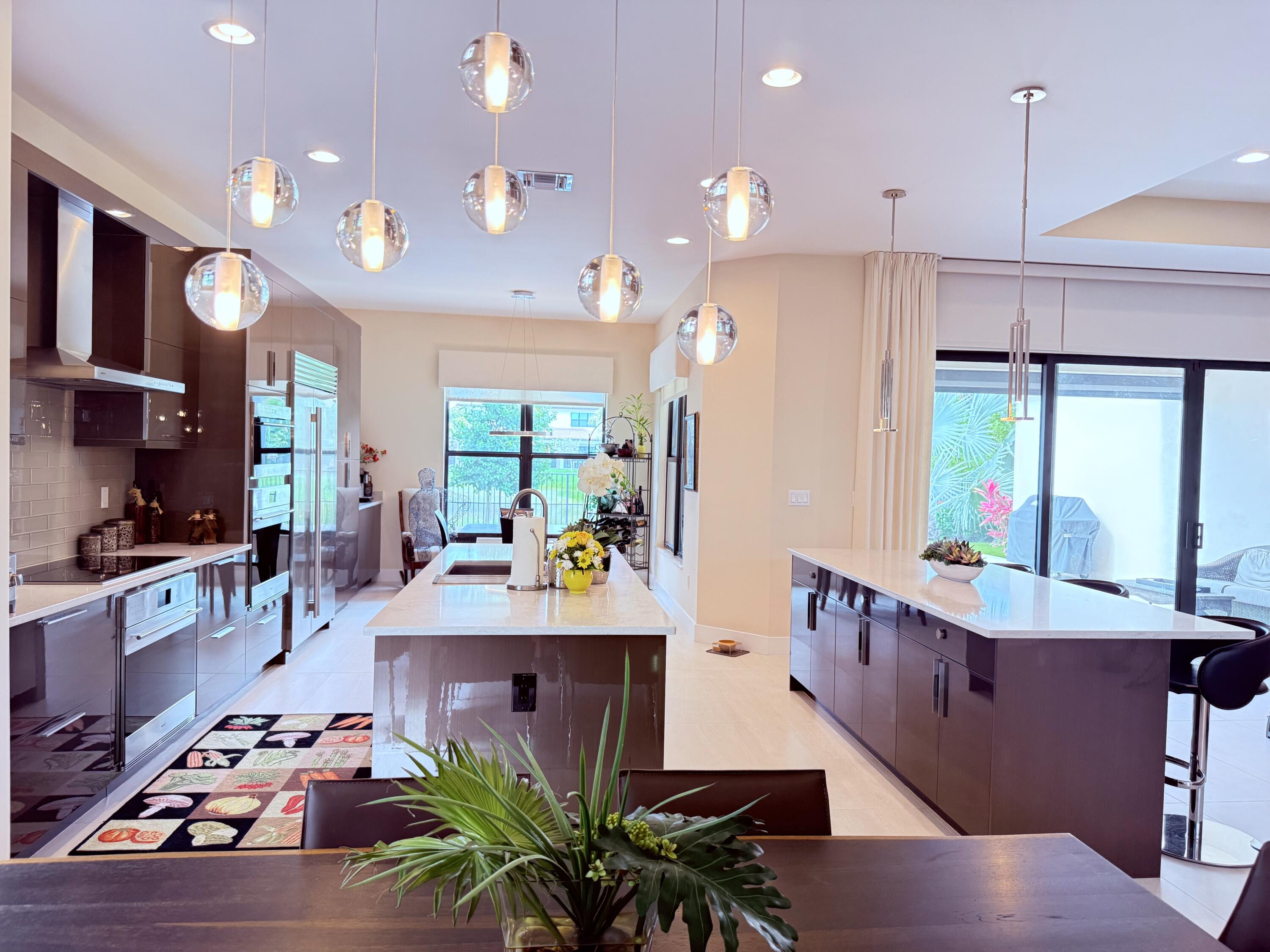 8575 Dearborn River Way Boca Raton, FL 33496 - Photo 8 of 32 a kitchen with stainless steel appliances a dining table chairs sink and living room view