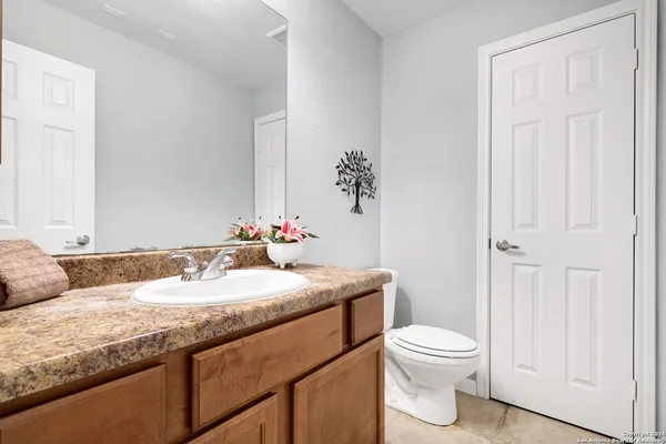 a bathroom with a granite countertop sink and a mirror