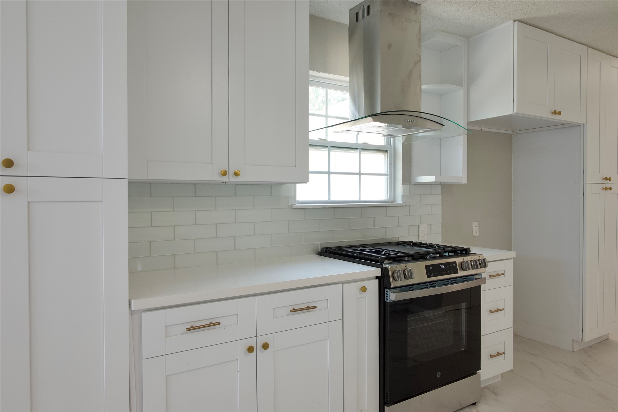 5111 Pinewilde Drive Houston, TX 77066 - Photo 13 of 37 a kitchen with granite countertop white cabinets and window