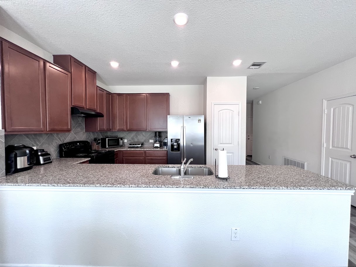 7900 Crystalbrook West Austin, TX 78724 - Photo 17 of 27 a kitchen with stainless steel appliances granite countertop a sink refrigerator and cabinets