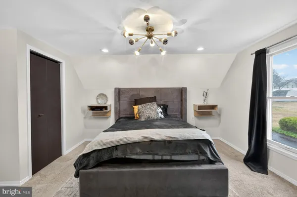 a bedroom with a large bed and a chandelier