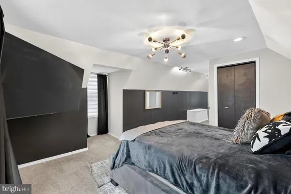 a bedroom with a large bed and a chandelier