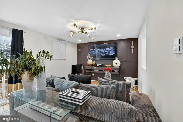a living room with furniture a chandelier and a potted plant