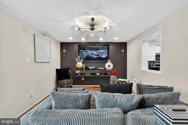 a living room with furniture a chandelier and a fireplace