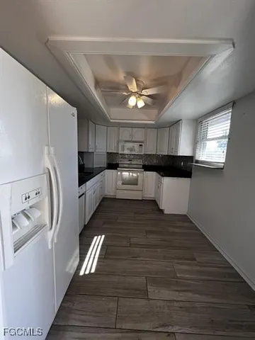 a kitchen with stainless steel appliances a refrigerator a sink and white cabinets