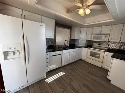 a kitchen with granite countertop white cabinets and black appliances