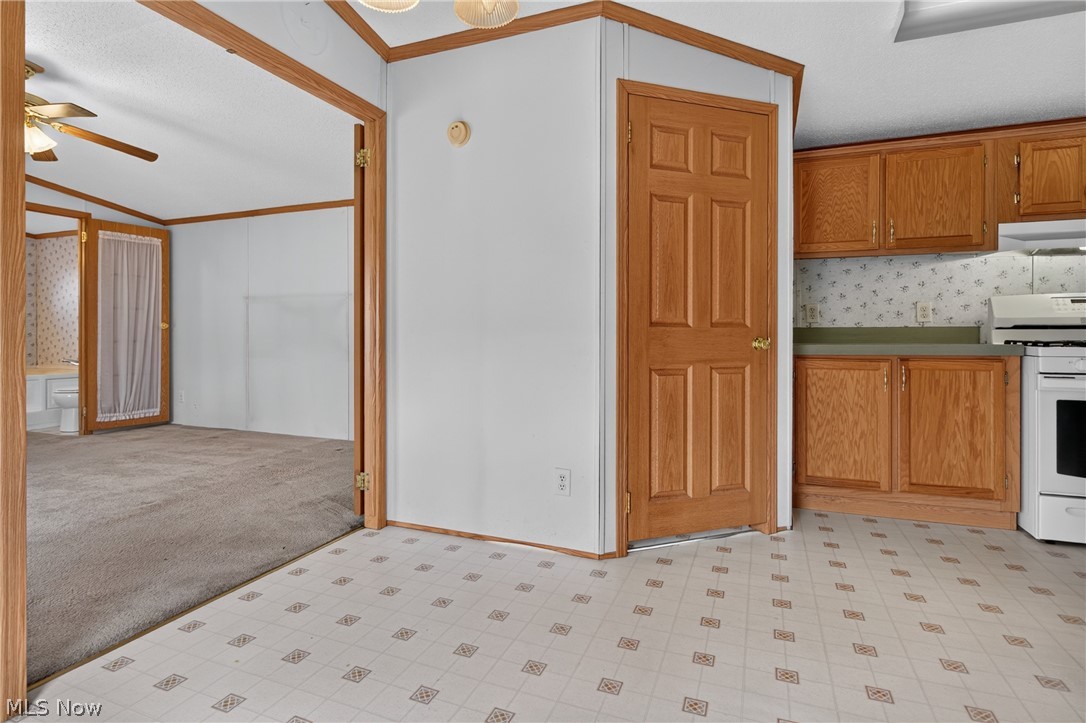 35157 Center Ridge Road, Unit 153 North Ridgeville, OH 44039 - Photo 20 of 35 Kitchen area featuring wood-finish cabinetry, a white range, and a patterned flooring