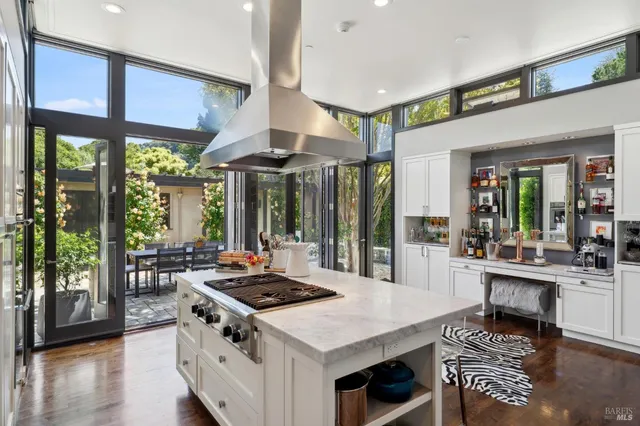 a kitchen with stainless steel appliances granite countertop a stove and a view of living room