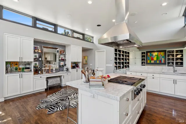 a kitchen that has a lot of cabinets in it and wooden floors