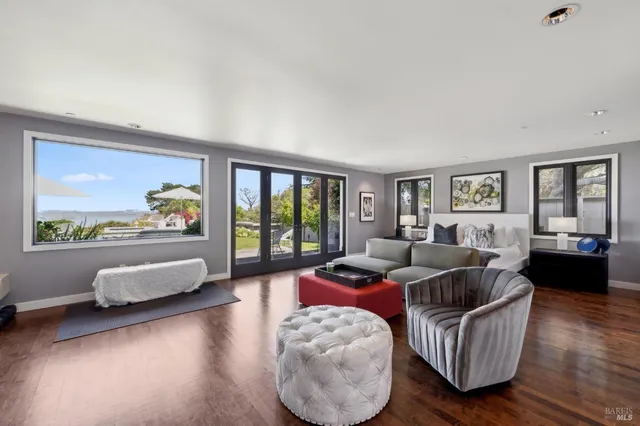 a spacious bedroom with a bed a couch and a large window