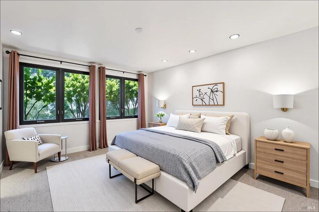 a bedroom with a bed and a large window