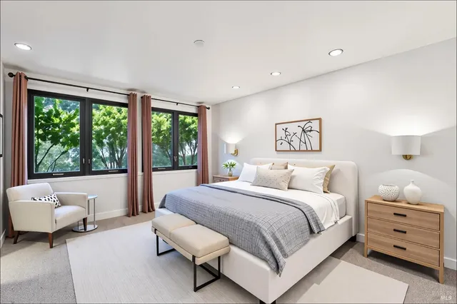 a bedroom with a bed and a large window