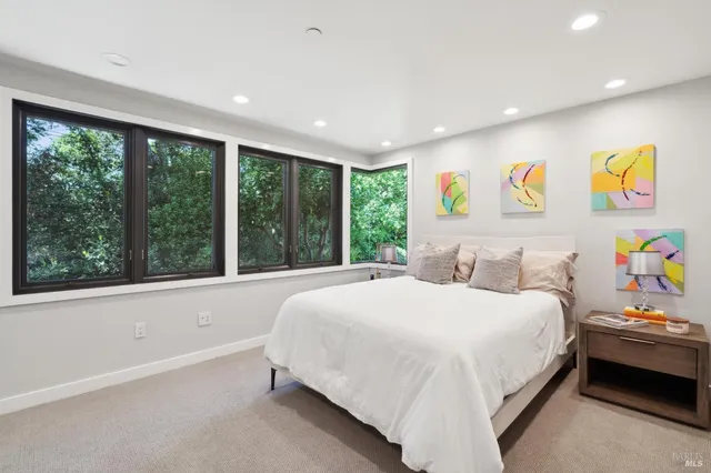 a bedroom with a bed and painting on the wall