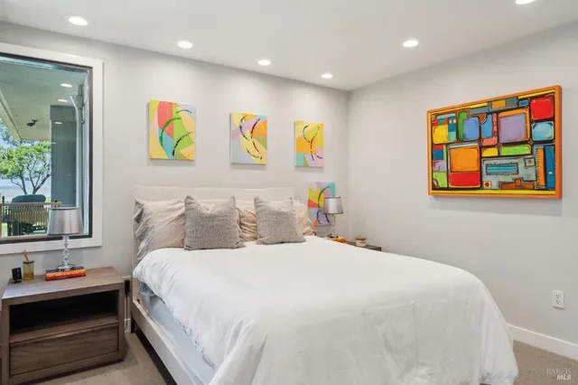 a bedroom with a bed and a painting on the wall