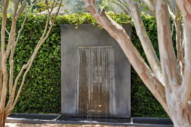 a view of a patio with table and chairs potted plants and large tree