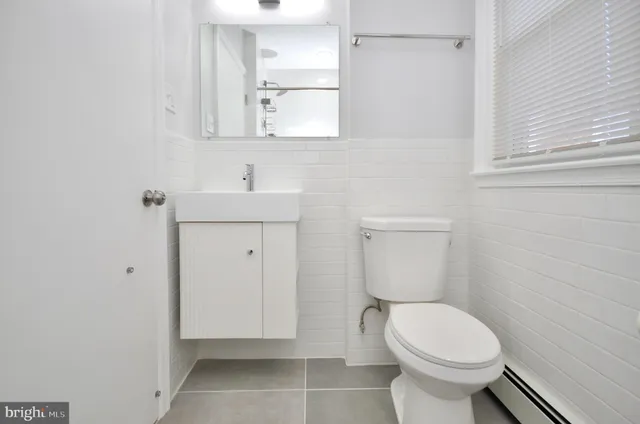 a bathroom with a sink a toilet and mirror