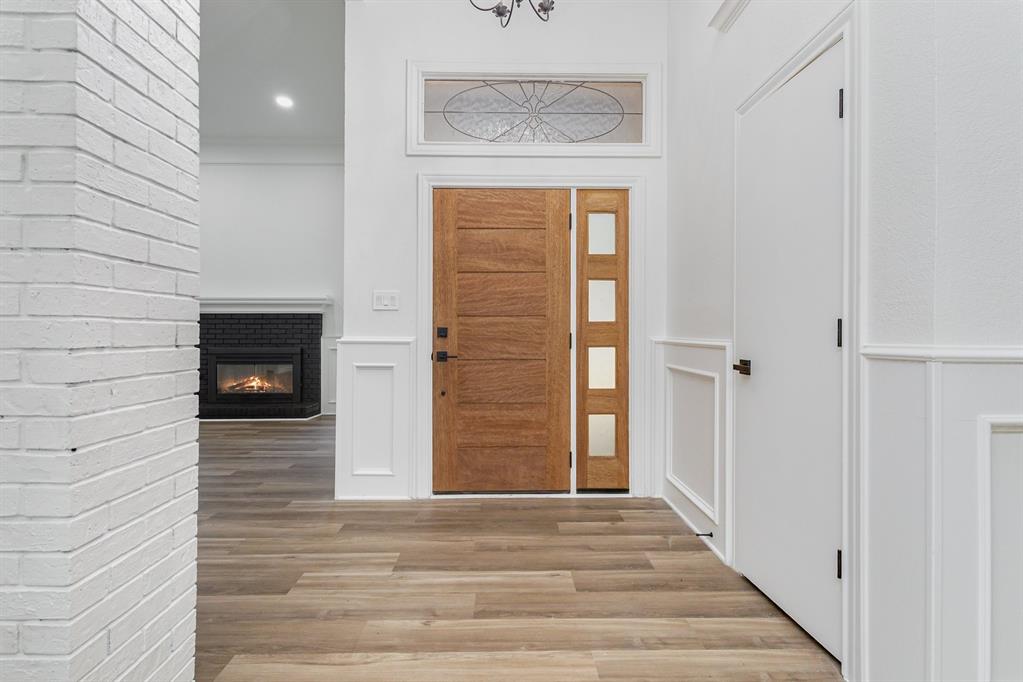 922 Sycamore Creek Road Allen, TX 75002 - Photo 12 of 38 Entrance foyer with light wood-type flooring, a fireplace, and crown molding