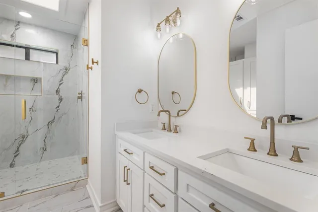 a bathroom with a double vanity sink mirror double and a bathtub