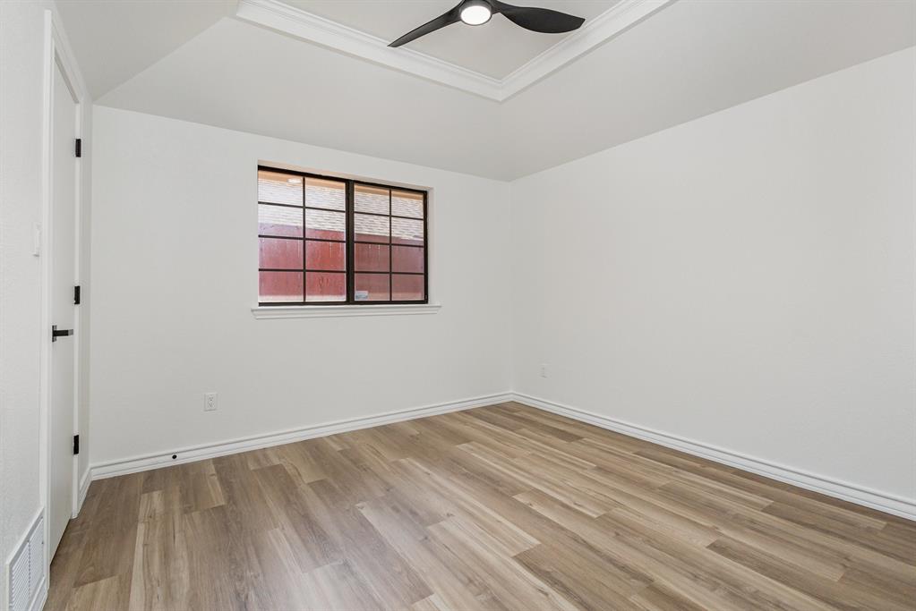 922 Sycamore Creek Road Allen, TX 75002 - Photo 26 of 38 Unfurnished room with light wood-style flooring, crown molding, ceiling fan, and a raised ceiling
