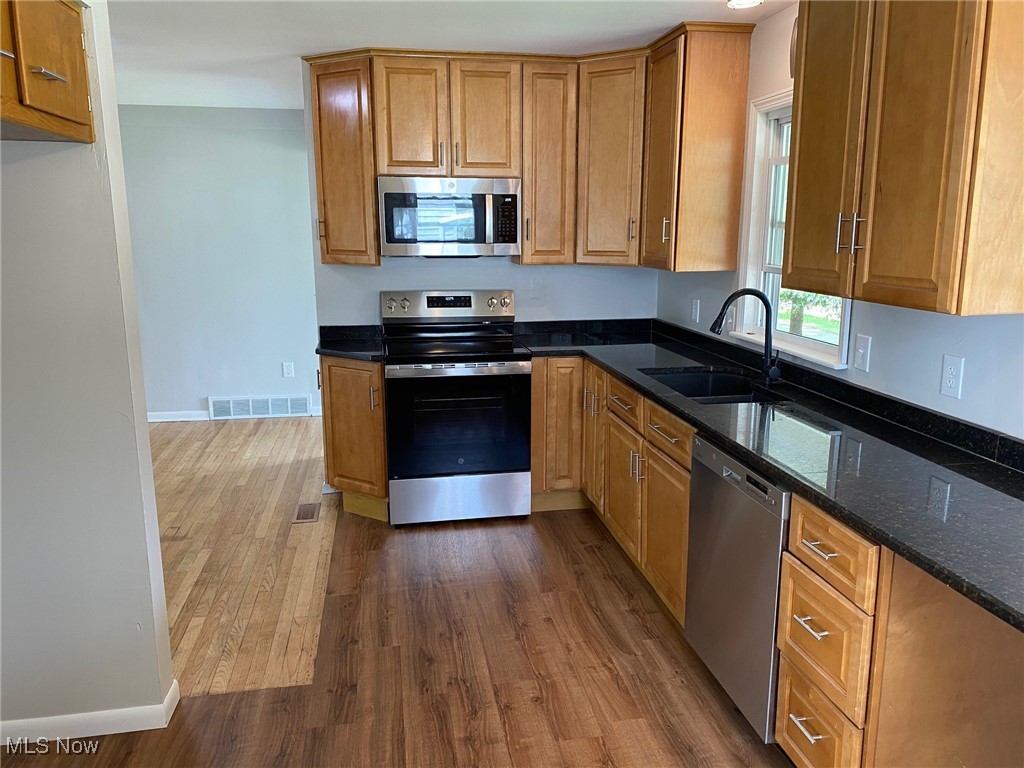 6261 Springwood Road Cleveland, OH 44130 - Photo 7 of 27 Kitchen featuring stainless steel appliances, vinyl plank flooring, and dark granite counters