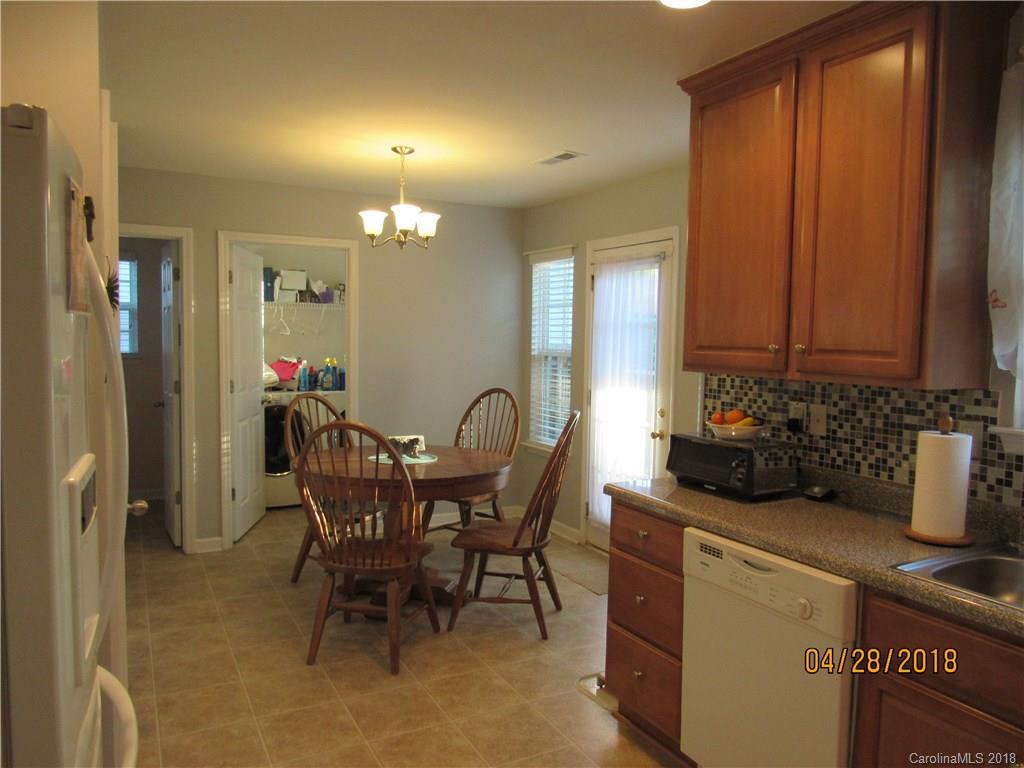 7606 West Berkeley Road Denver, NC 28037 - Photo 6 of 22 a kitchen with a table chairs and cabinets