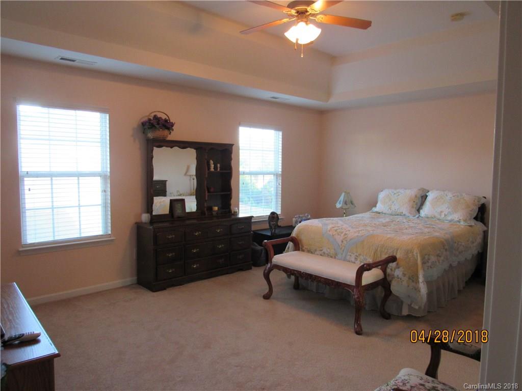 7606 West Berkeley Road Denver, NC 28037 - Photo 10 of 22 a spacious bedroom with a bed and a chandelier