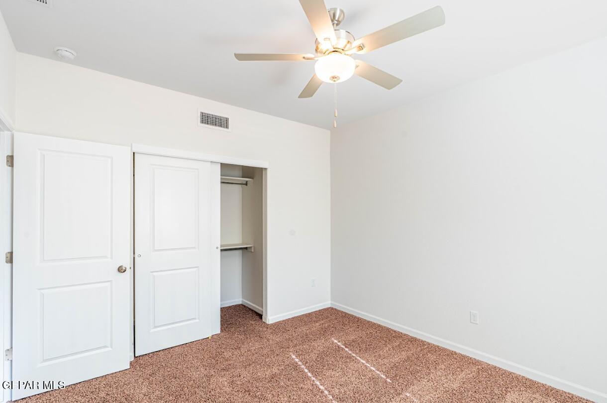 5921 Ruidoso Downs Street El Paso, TX 79932 - Photo 4 of 4 an empty room with closet and a ceiling fan