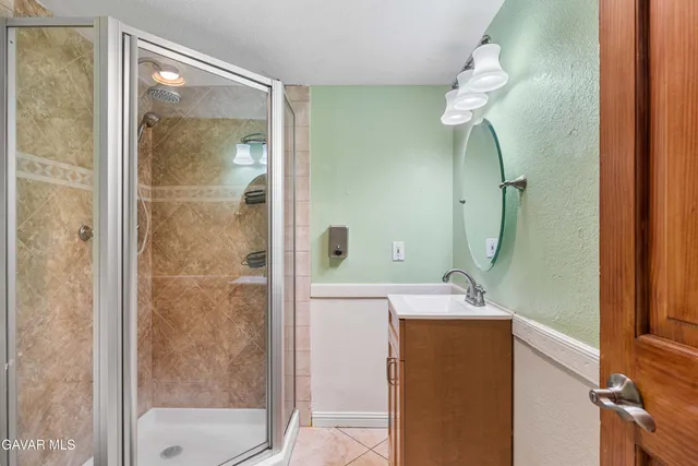 a bathroom with a sink a mirror and a shower