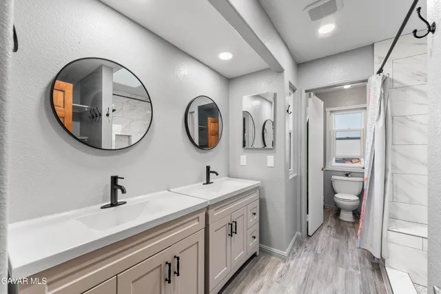 a bathroom with a double vanity sink and a mirror