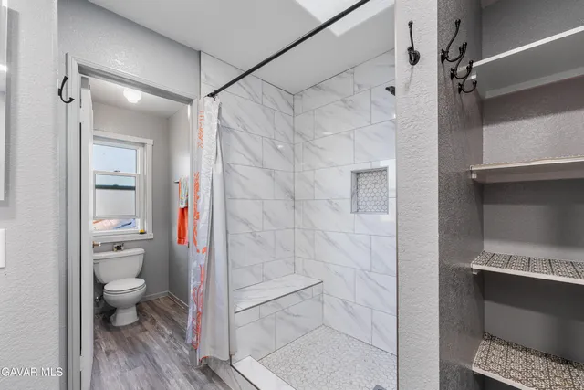 a bathroom with a toilet and a shower