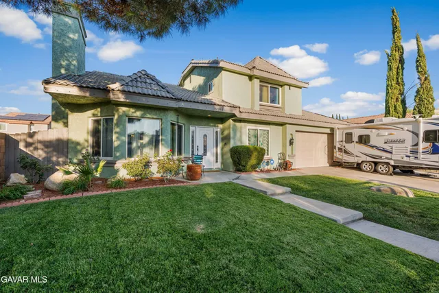 a front view of a house with a garden and plants