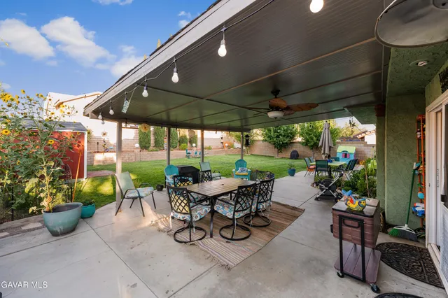a view of a patio with a table and chairs under an umbrella