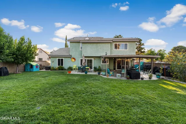 a view of a house with a yard and sitting area