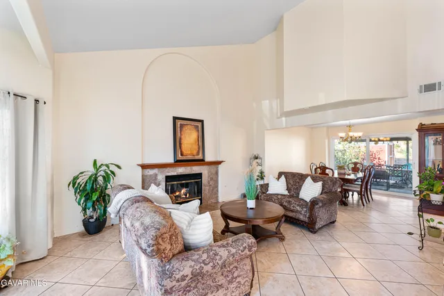 a living room with furniture a fireplace and a potted plant